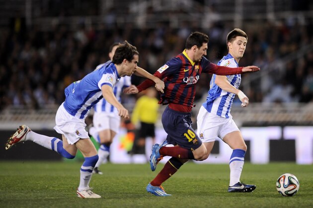 FC Barcelona's Lionel Messi of Argentina, center, goes for the ball between Real Sociedad's Jon Gaztanaga, right, and Mikel Gonzalez, left, before to scoring his goal, during their Spanish Copa del Rey semifinal second leg soccer match, at Anoeta stadium, in San Sebastian northern Spain, Wednesday, Feb. 12, 2014. (AP Photo/Alvaro Barrientos)