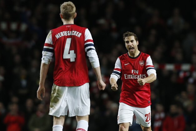 Arsenal's Mathieu Flamini, right, and Per Mertesacker celebrate their win against Liverpool at the end of their English FA Cup fifth round soccer match at Emirates Stadium in London, Sunday, Feb. 16, 2014. (AP Photo / Sang Tan)