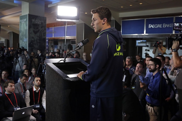 Texas A&M quarterback Johnny Manziel is surrounded by the media as answers a question during a news conference at the NFL football scouting combine in Indianapolis, Friday, Feb. 21, 2014. (AP Photo/Michael Conroy)
