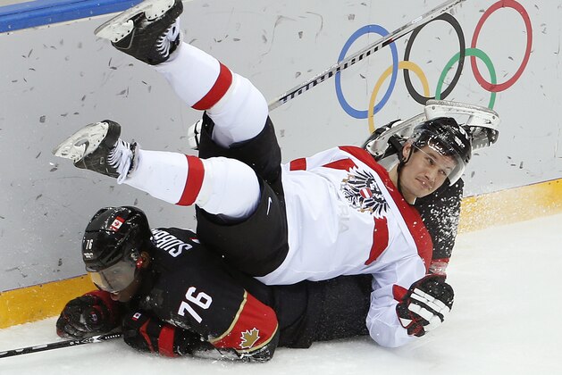 Austria forward Oliver Setzinger is upended by Canada forward P.K. Subban in the third period of a men's ice hockey game at the 2014 Winter Olympics, Friday, Feb. 14, 2014, in Sochi, Russia. (AP Photo/Julio Cortez)
