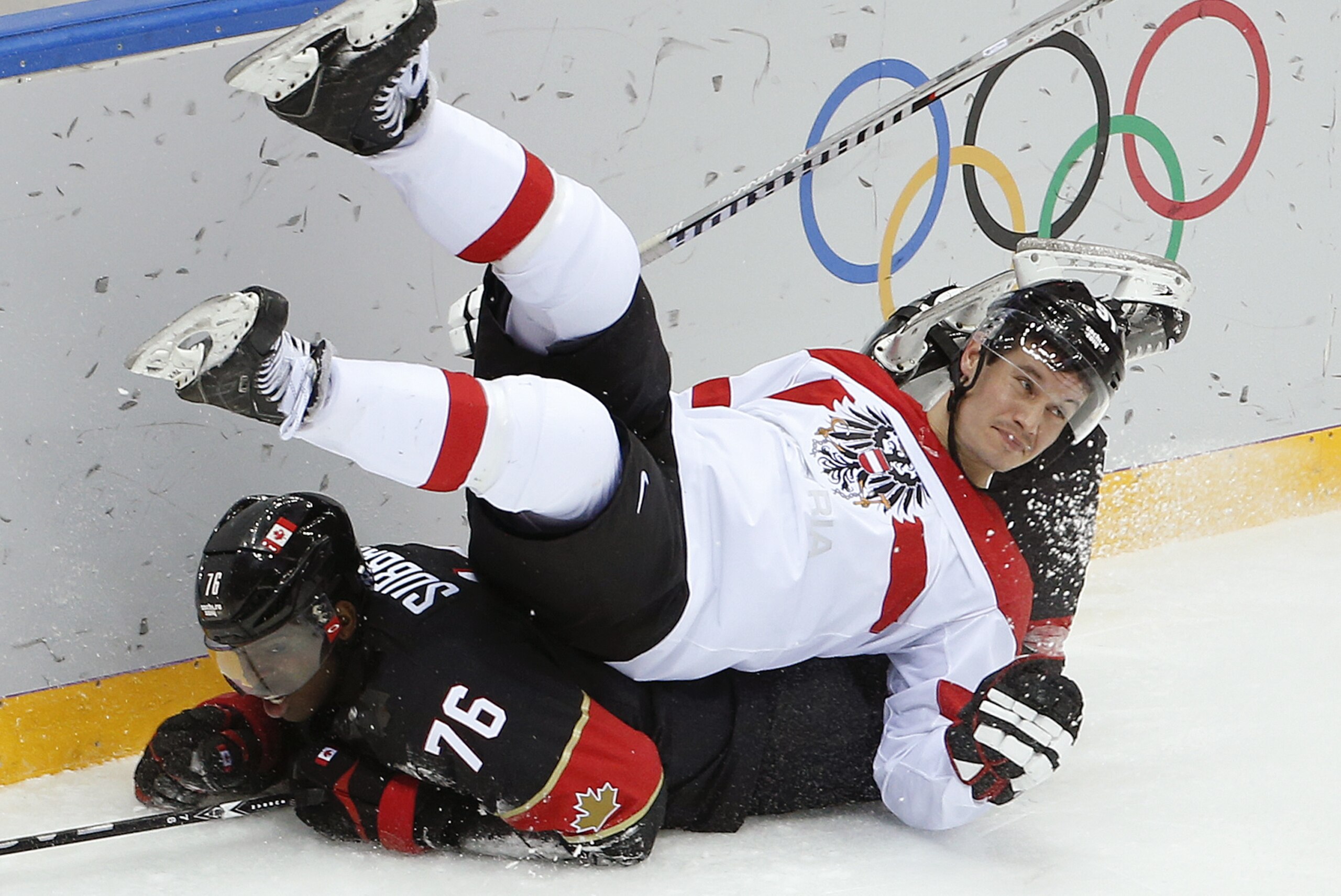 Austria forward Oliver Setzinger is upended by Canada forward P.K. Subban in the third period of a men's ice hockey game at the 2014 Winter Olympics, Friday, Feb. 14, 2014, in Sochi, Russia. (AP Photo/Julio Cortez)