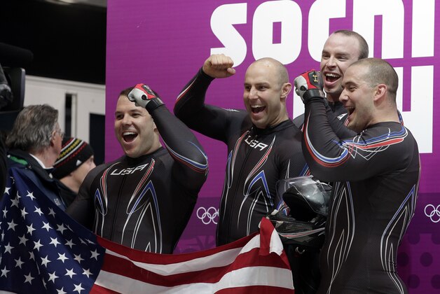 The team from the United States USA-2, with Nick Cunningham, Justin Olsen, Johnny Quinn and Dallas Robinson, react in the finish area after their second run during the men's four-man bobsled competition at the 2014 Winter Olympics, Saturday, Feb. 22, 2014, in Krasnaya Polyana, Russia. (AP Photo/Michael Sohn)