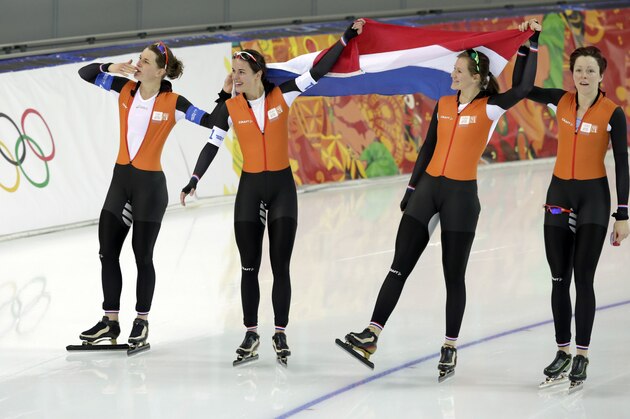 Athletes from the Netherlands, left to right, Ireen Wust, Marrit Leenstra, Lotte van Beek and Jorien ter Mors hold their national flag and celebrate their gold in the women's team pursuit at the Adler Arena Skating Center at the 2014 Winter Olympics, Saturday, Feb. 22, 2014, in Sochi, Russia. (AP Photo/Matt Dunham)