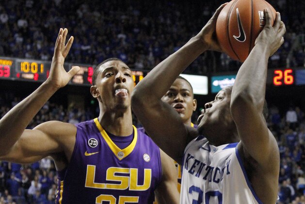 Kentucky's Julius Randle (30) looks for an opening on LSU's Jordan Mickey (25) and Jarell Martin during the second half of an NCAA college basketball game, Saturday, Feb. 22, 2014, in Lexington, Ky. Kentucky won 77-76. (AP Photo/James Crisp)