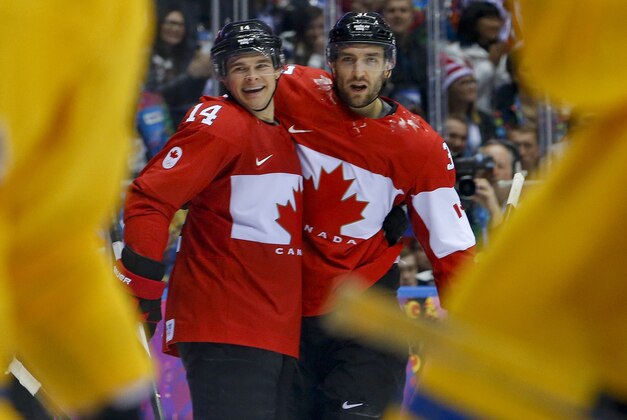 Canada forward Chris Kunitz, left, celebrates with forward Patrice Bergeron after scoring against Sweden during the third period of the men's gold medal ice hockey game at the 2014 Winter Olympics, Sunday, Feb. 23, 2014, in Sochi, Russia. (AP Photo/Matt Slocum)