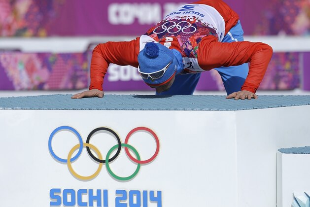 Russia's Alexander Legkov kisses the podium during the flower ceremony after winning the gold medal in the men's 50K cross-country race at the 2014 Winter Olympics, Sunday, Feb. 23, 2014, in Krasnaya Polyana, Russia. (AP Photo/Gregorio Borgia)