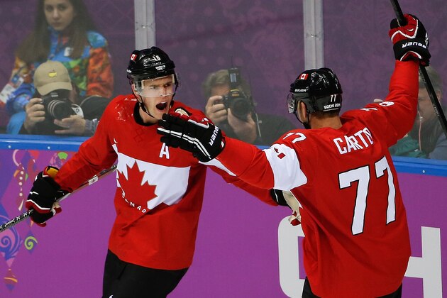 Jonathan Toews of Canada (16) celebrates this goal with teammate Jeff Carter (77) during the first period of the men's gold medal ice hockey game against Sweden at the 2014 Winter Olympics, Sunday, Feb. 23, 2014, in Sochi, Russia. (AP Photo/Petr David Josek)