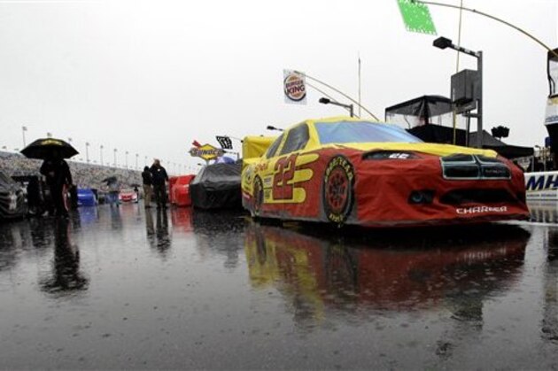AJ Allmendinger's car (22) and others remain parked on pit road due to a rain delay before the start of the Daytona 500 auto race at Daytona International Speedway in Daytona Beach, Fla., Sunday, Feb. 26, 2012. (AP Photo/John Raoux)
