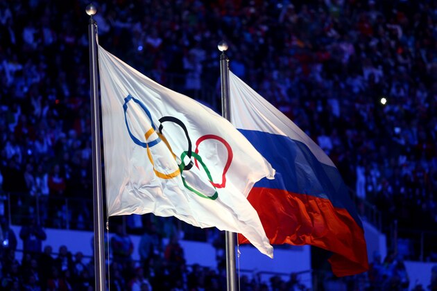 SOCHI, RUSSIA - FEBRUARY 23:  The Olympic flag and Russian flag are raised as the Russian National Anthem is sung during the 2014 Sochi Winter Olympics Closing Ceremony at Fisht Olympic Stadium on February 23, 2014 in Sochi, Russia.  (Photo by Paul Gilham/Getty Images)