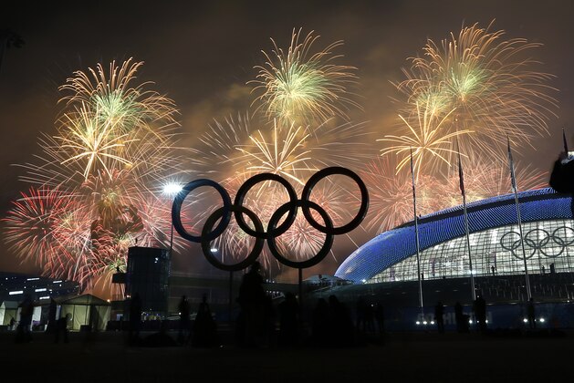 A man takes a photograph of fireworks during the closing ceremony of the 2014 Winter Olympics, Sunday, Feb. 23, 2014, in Sochi, Russia. (AP Photo/Petr David Josek)