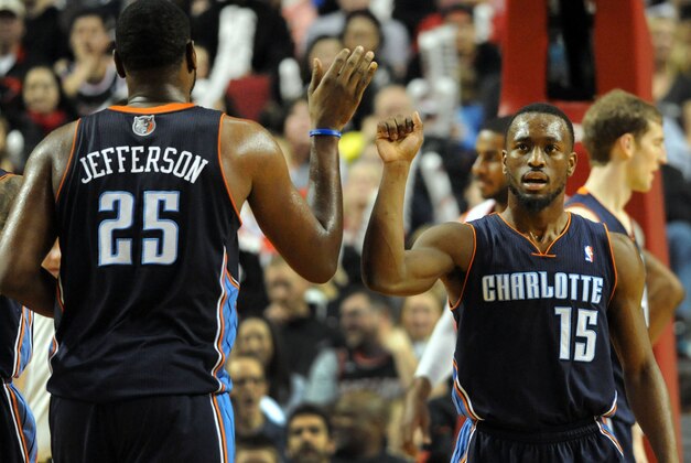 Jan. 02, 2014; Portland, OR, USA; Charlotte Bobcats point guard Kemba Walker (15) celebrates with center Al Jefferson (25) after scoring a basket during the third quarter of the game against the Portland Trail Blazers at the Moda Center. Mandatory Credit: Steve Dykes-USA TODAY Sports