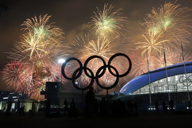 A man takes a photograph of fireworks during the closing ceremony of the 2014 Winter Olympics, Sunday, Feb. 23, 2014, in Sochi, Russia. (AP Photo/Petr David Josek)