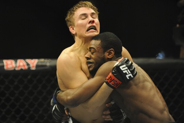 Feb 22, 2014; Las Vegas, NV, USA; Aljamain Sterling (blue gloves) attempts to take down Cody Gibson (red gloves) during their UFC bantamweight bout at Mandalay Bay. Sterling won 29-28 by unanimous decision. Mandatory Credit: Stephen R. Sylvanie-USA TODAY Sports