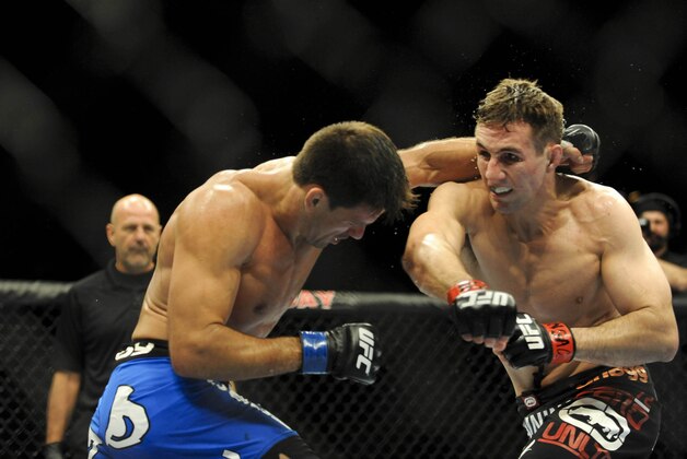 Feb 22, 2014; Las Vegas, NV, USA;  Rory MacDonald (red gloves) throws a punch at Demian Maia (blue gloves) during their UFC welterweight bout at Mandalay Bay. MacDonald won by way of a 29-28 decision. Mandatory Credit: Stephen R. Sylvanie-USA TODAY Sports