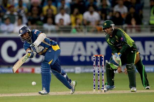 DUBAI, UNITED ARAB EMIRATES - DECEMBER 20:  TM Dilshan of Sri Lanka bats as Umar Akmal of Pakistan looks on during the second One-Day International (ODI ) match between Sri Lanka and Pakistan at the Dubai Sports City Cricket Stadium on December 20, 2013 in Dubai, United Arab Emirates.  (Photo by Francois Nel/Getty Images)