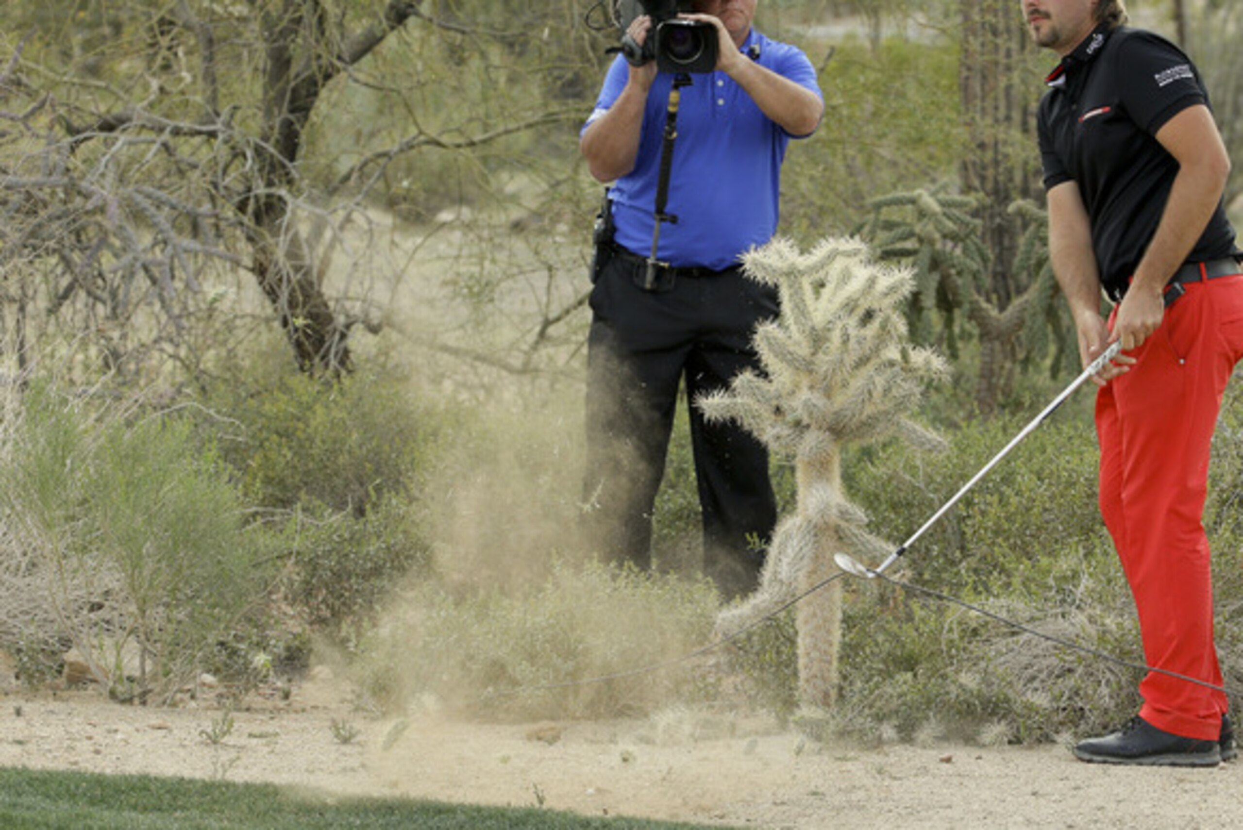 Victor Dubuisson, of France, hits near a cactus on the 19th hole in his championship match against Jason Day, of  Australia, during the Match Play Championship golf tournament, Sunday, Feb. 23, 2014, in Marana, Ariz. (AP Photo/Ted S. Warren)