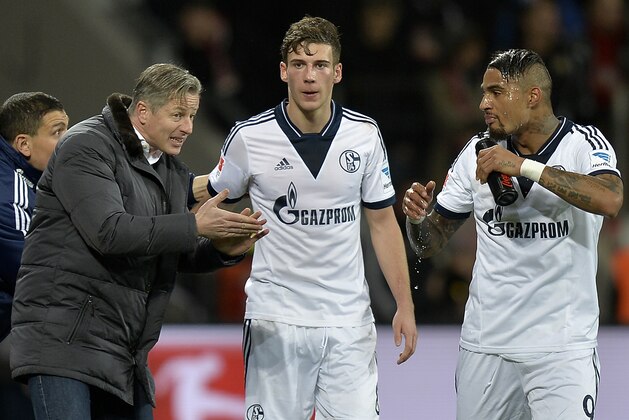 Schalke head coach Jens Keller, left, speaks to Schalke's scorer Leon Goretzka and Kevin-Prince Boateng of Ghana, from left, during the German Bundesliga soccer match between Bayer Leverkusen and FC Schalke 04 in Leverkusen, Germany, Saturday, Feb. 15, 2014. (AP Photo/Martin Meissner)
