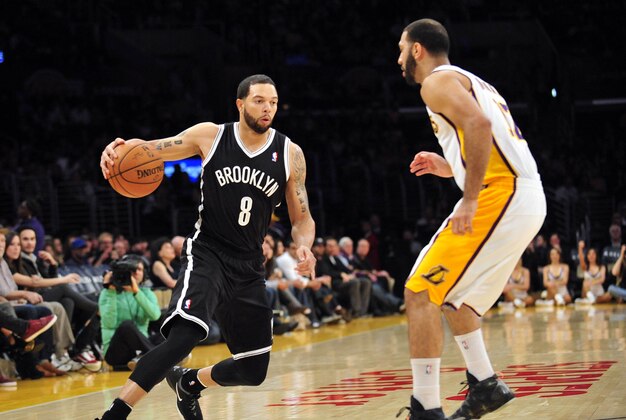 February 23, 2014; Los Angeles, CA, USA; Brooklyn Nets point guard Deron Williams (8) moves the ball against Los Angeles Lakers point guard Kendall Marshall (12) during the first half at Staples Center. Mandatory Credit: Gary A. Vasquez-USA TODAY Sports