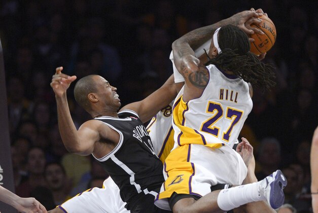 Los Angeles Lakers forward Jordan Hill, right, tries to put up a shot as Brooklyn Nets center Jason Collins blocks it during the first half of an NBA basketball, Sunday, Feb. 23, 2014, in Los Angeles. (AP Photo/Mark J. Terrill)