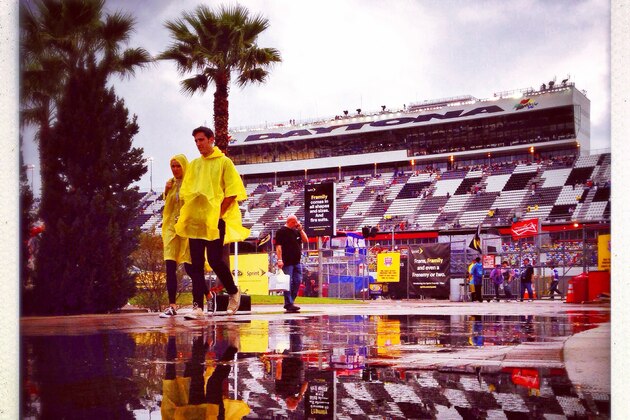 DAYTONA BEACH, FL - FEBRUARY 23:  (EDITORS NOTE: This image was processed using digital filters)  People are reflected in a puddle during a rain delay in the NASCAR Sprint Cup Series Daytona 500 at Daytona International Speedway on February 23, 2014 in Daytona Beach, Florida.  (Photo by Tom Pennington/Getty Images)
