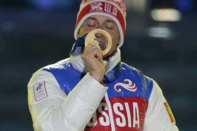 Russia's gold medal winner Alexander Legkov kisses his medal during the medals ceremony for the men's 50-kilometer cross-country race during the closing ceremony of the 2014 Winter Olympics, Sunday, Feb. 23, 2014, in Sochi, Russia. (AP Photo/Charlie Riedel)