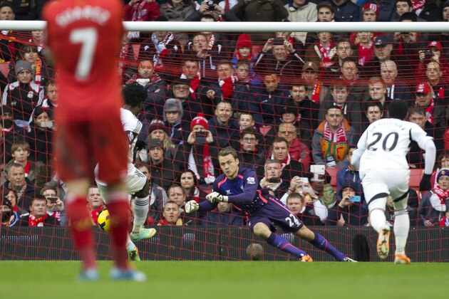 Liverpool's Simon Mignolet, centre, dives in vain as he attempts to stop a penalty by Swansea City's Wilfried Bony, centre left, during their English Premier League soccer match at Anfield Stadium, Liverpool, England, Sunday Feb. 23, 2014. (AP Photo/Jon Super)