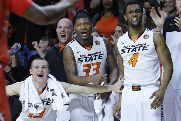 Oklahoma State guard Phil Forte (13), guard Marcus Smart (33) and wing Brian Williams (4) cheer on the bench following a dunk by teammate Le'Bryan Nash in the second half of an NCAA college basketball game against Texas Tech in Stillwater, Okla., Saturday, Feb. 22, 2014. Oklahoma State won 84-62. (AP Photo/Sue Ogrocki)