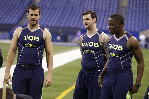 Central Florida quarterback Blake Bortles, left, Alabama quarterback AJ McCarron, center, and Louisville quarterback Teddy Bridgewater watch a drill at the NFL football scouting combine in Indianapolis, Sunday, Feb. 23, 2014. (AP Photo/Michael Conroy)