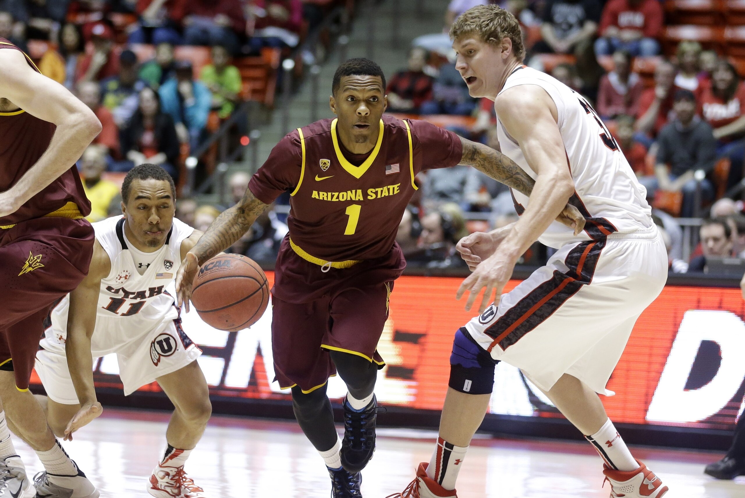 Arizona State's Jahii Carson (1) drives between Utah's Brandon Taylor (11) and Dallin Bachynski (31) in the first half of an NCAA college basketball game Sunday, Feb. 23, 2014, in Salt Lake City. (AP Photo/Rick Bowmer)