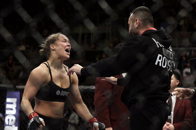 Ronda Rousey, left, hugs her trainer Edmond Tarverdyan after defeating Sara McMann in a UFC 170 mixed martial arts women's bantamweight title fight on Saturday, Feb. 22, 2014, in Las Vegas. (AP Photo/Isaac Brekken)