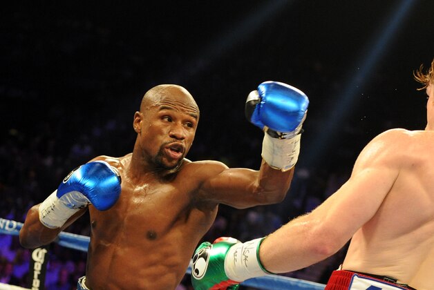 Sep 14, 2013; Las Vegas, NV, USA; Floyd Mayweather Jr. (blue gloves) and Canelo Alvarez battle it during their during their WBC and WBA super welterweight titles fight at MGM Grand Garden Arena. Mandatory Credit: Jayne Kamin-Oncea-USA TODAY Sports