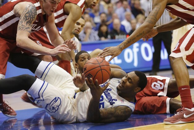 Kansas forward Tarik Black (25) comes up with the ball between four Oklahoma defenders including Oklahoma forward Ryan Spangler, left, and guard Je'lon Hornbeak, right, during the first half of an NCAA college basketball game in Lawrence, Kan., Monday, Feb. 24, 2014. (AP Photo/Orlin Wagner)