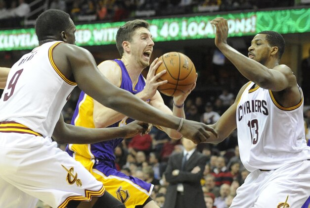Feb 5, 2014; Cleveland, OH, USA; Los Angeles Lakers power forward Ryan Kelly (center) drives between Cleveland Cavaliers small forward Luol Deng (9) and power forward Tristan Thompson in the second quarter at Quicken Loans Arena. Mandatory Credit: David Richard-USA TODAY Sports