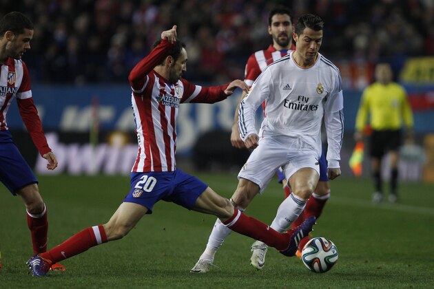 Atletico's Juanfran in action with Real's Cristiano Ronaldo during a semi final, 2nd leg, Copa del Rey soccer derby match between Real Madrid and Atletico Madrid at the Vicente Calderon Stadium in Madrid, Tuesday Feb. 11 , 2014.  (AP Photo/Gabriel Pecot)