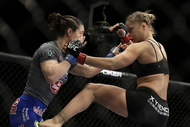 Ronda Rousey, right, kicks Sara McMann during a UFC 170 mixed martial arts women's bantamweight title fight on Saturday, Feb. 22, 2014, in Las Vegas. Rousey won by TKO. (AP Photo/Isaac Brekken)