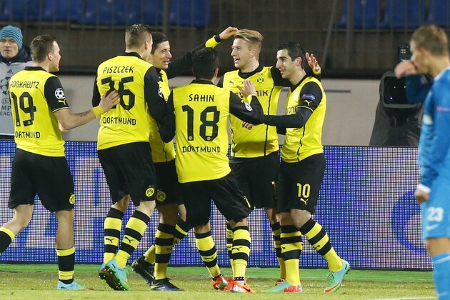 Zenit's Andrey Arshavin, right, watches as Borussia's Henrikh Mkhitaryan, center right, and other team players celebrate their goal against Zenit during the Champions League soccer match between Zenit St.Petersburg and  Borussia Dortmund at Petrovsky stadium in St.Petersburg, Russia, on Tuesday, Feb. 25, 2014. (AP Photo/Dmitry Lovetsky)