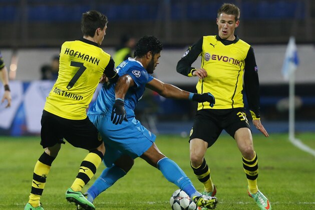 Borussia's Jonas Hofmann, left, and Erik Durm, right, stop Zenit's Hulk during the Champions League soccer match between Zenit St.Petersburg and  Borussia Dortmund at Petrovsky stadium in St.Petersburg, Russia, on Tuesday, Feb. 25, 2014. (AP Photo/Dmitry Lovetsky)