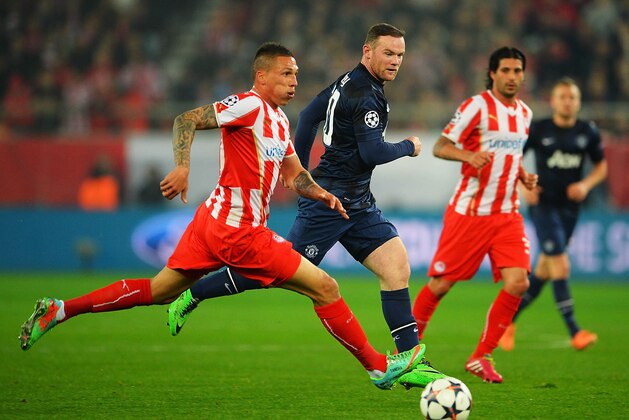 PIRAEUS, GREECE - FEBRUARY 25:  Jose Holebas (L) of Olympiacos holds off the challenge of Wayne Rooney of Manchester United during the UEFA Champions League Round of 16 first leg match between Olympiacos FC and Manchester United at Karaiskakis Stadium on February 25, 2014 in Piraeus, Greece.  (Photo by Michael Regan/Getty Images)