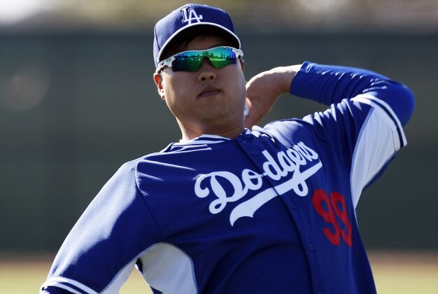 Feb 9, 2014; Glendale, AZ, USA; Los Angeles Dodgers starting pitcher Hyun-Jin Ryu (99) warms up during the first day of camp at Camelback Ranch. Mandatory Credit: Rick Scuteri-USA TODAY Sports