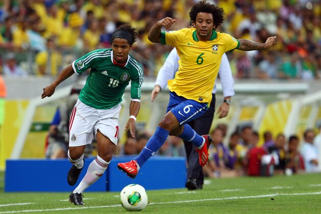 FORTALEZA, BRAZIL - JUNE 19:  Giovani dos Santos of Mexico competes with Marcelo of Brazil  during the FIFA Confederations Cup Brazil 2013 Group A match between Brazil and Mexico at Castelao on June 19, 2013 in Fortaleza, Brazil.  (Photo by Robert Cianflone/Getty Images)