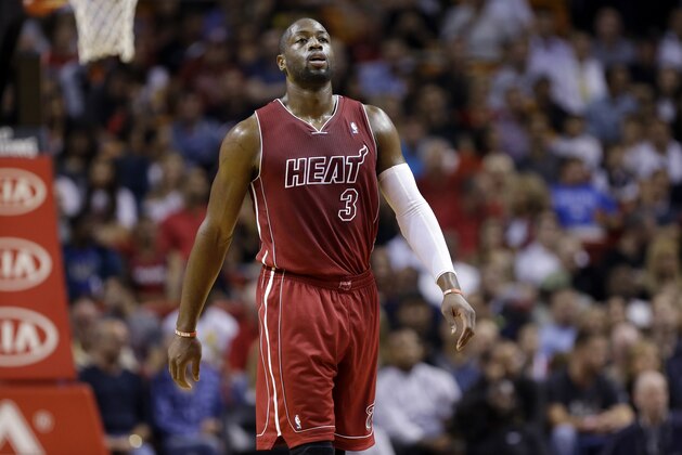 Miami Heat shooting guard Dwyane Wade (3) walks on the court during the first half of an NBA basketball game against the Phoenix Suns , Monday, Nov. 25, 2013, in Miami. (AP Photo/Lynne Sladky)