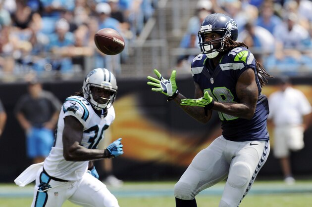 Sep 8, 2013; Charlotte, NC, USA; Seattle Seahawks wide receiver sidney Rice (18) catches a pass while pursued by Carolina Panthers safety Charles Godfrey (30) during the game at Bank of America Stadium. Mandatory Credit: Sam Sharpe-USA TODAY Sports