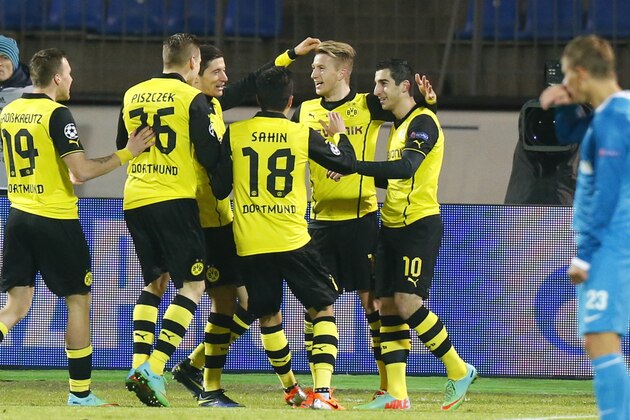 Zenit's Andrey Arshavin, right, watches as Borussia's Henrikh Mkhitaryan, center right, and other team players celebrate their goal against Zenit during the Champions League soccer match between Zenit St.Petersburg and  Borussia Dortmund at Petrovsky stadium in St.Petersburg, Russia, on Tuesday, Feb. 25, 2014. (AP Photo/Dmitry Lovetsky)