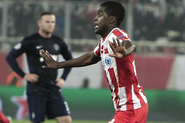 As Wayne Rooney looks on, Olympiakos&#x27; Joel Campbell celebrates after scoring the second goal of his team against Manchester United during their Champions League, round of 16, first leg soccer match at Georgios Karaiskakis stadium, in Piraeus port, near Athens, on Tuesday, Feb. 25, 2014. (AP Photo/Thanassis Stavrakis)