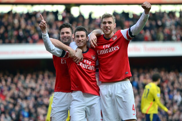 LONDON, ENGLAND - FEBRUARY 22:  Laurent Koscielny of Arsenal (C) celebrates with team-mates Olivier Giroud of Arsenal (L) and Per Mertesacker of Arsenal after scoring their third goal during the Barclays Premier League match between Arsenal and Sunderland at Emirates Stadium on February 22, 2014 in London, England.  (Photo by Michael Regan/Getty Images)