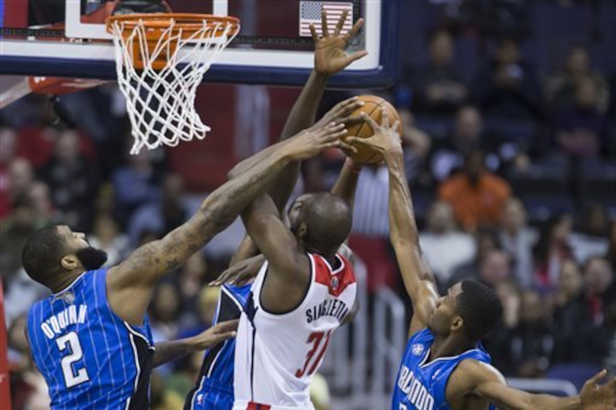 Washington Wizards forward Chris Singleton, drives to the basket against Orlando Magic forward Kyle O'Quinn, left, forward Andrew Nicholson, center, and forward Maurice Harkless during the first half of an NBA basketball game, Tuesday, Feb. 25, 2014, in Washington. (AP Photo/ Evan Vucci)