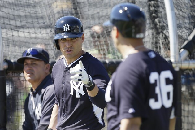 New York Yankees center fielder Jacoby Ellsbury, center, talks to teammate Carlos Beltran, right, during spring training baseball practice Thursday, Feb. 20, 2014, in Tampa, Fla. (AP Photo/Charlie Neibergall)