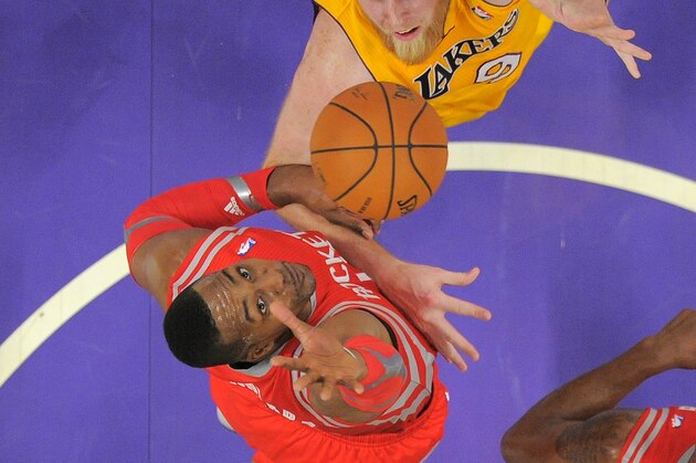 Houston Rockets center Dwight Howard, below, jumps to block the shot of Los Angeles Lakers center Chris Kaman during the first half of an NBA basketball game, Wednesday, Feb. 19, 2014, in Los Angeles. (AP Photo/Mark J. Terrill)