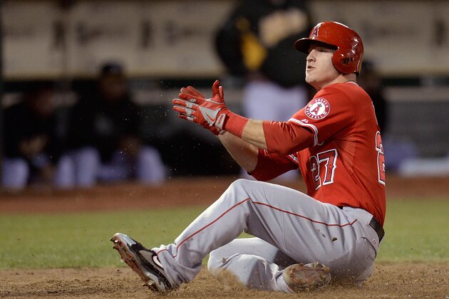 OAKLAND, CA - SEPTEMBER 16:  Mike Trout #27 of the Los Angeles Angels of Anaheim scores on a bases loaded two-run single from Kole Calhoun #56 during the fifth inning against the Oakland Athletics at O.co Coliseum on September 16, 2013 in Oakland, California.  (Photo by Thearon W. Henderson/Getty Images)