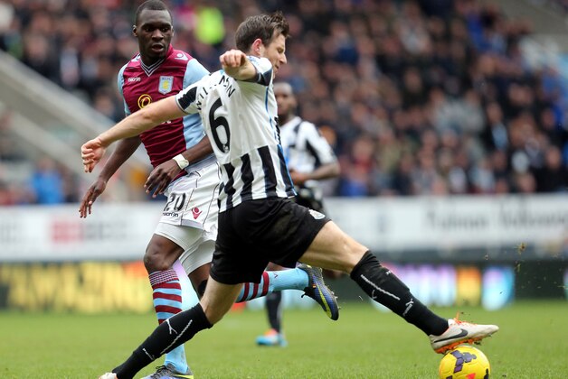Aston Villa's Christian Benteke, left, has his shot towards goal stopped by Newcastle United's Mike Williamson, right, during their English Premier League soccer match at St James' Park, Newcastle, England, Sunday, Feb. 23, 2014. (AP Photo/Scott Heppell)